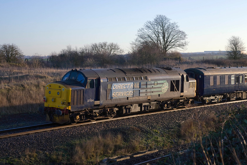 37194, outward leg of The Deviatoner, 06.22 Crewe-Ely Papworth Sidings (1Z20), Irchester Junction SP922673 
 About to celebrates its fiftieth birthday (16.03.14) 37194 brings up the rear of The Deviatoner railtour running as 1Z20 from Crewe to Ely's Papworth sidings. The train is seen on the bi-directional slow line at Irchester Junction just south of Wellingborough. The warehouse roofs of Rushden's Sander's Lodge industrial estate can just be seen on the horizon. 
 Keywords: 37194 The Deviatoner 06.22 Crewe-Ely Papworth Sidings 1Z20 Irchester Junction SP922673 DRS Direct Rail Services Pathfinder Tours