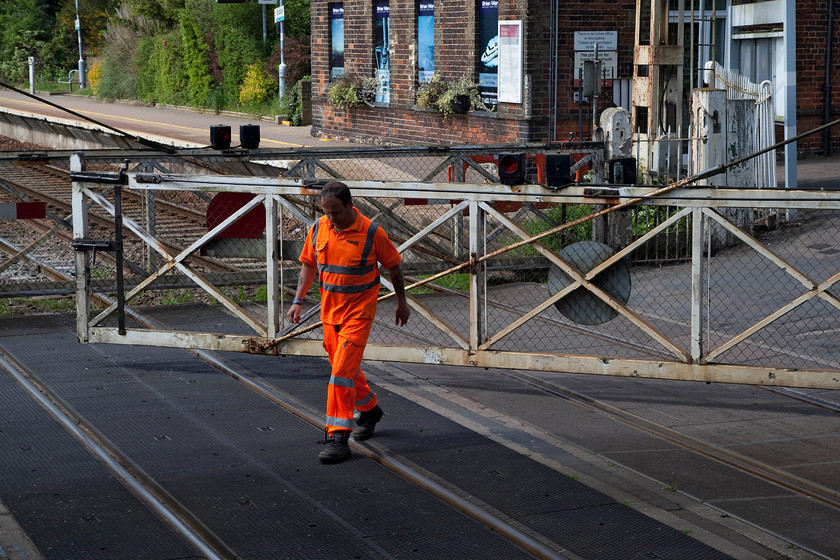 Opening crossing gates, Brundall Level Crossing 
 The crossing keeper at Brundall opens the gates to allow the passage of road users after a train has passed. In the short time Andy and I were at Brundall, he was kept busy as the number of trains passing was pretty regular. In the quiet environs of Brundall, I am sure that that the regular and intrusive crossing siren will cause some issues with the locals when the automatic barriers are installed soon. 
 Keywords: Opening crossing gates, Brundall Level Crossing