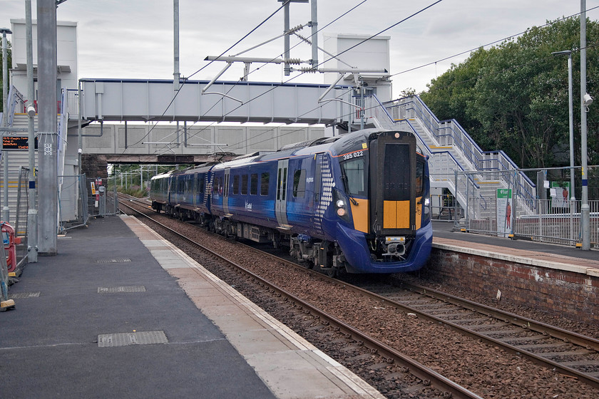 385022, SR 15.03 Glasgow Central-Edinburgh Waverley (1Y88, 6L), Cleland station 
 One of ScotRail's new class 385 arrives at Cleland station forming the 15.03 Glasgow Central to Edinburgh Waverley. Like many stations on this recently electrified line, a lot of work was taking place to upgrade their facilities. However, they all looked very similar with their grey and somewhat over-engineered structures. Despite a regular train service, Andy and I saw very few passengers on the platforms. 
 Keywords: 385022 15.03 Glasgow Central-Edinburgh Waverley 1Y88 Cleland station