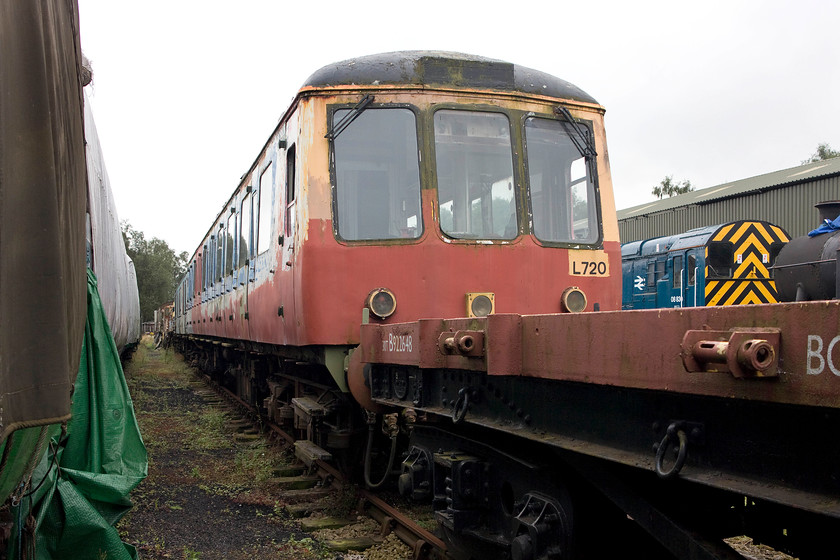 W51396 (Set L720), undergoing restoration, Rowsley yard 
 This driving coach of Class 117 DMU set L720 at Peak Rail's Rowlsey depot has yet to undergo the transformation that W51354 has had. With evidence of its Network SouthEast paintwork still in visible on the side, it has had a lot of red primer applied in an effort to keep the worst of the ravages of rust away. Let's hope that time an resources allow this project to be finished and for it to be reunited with its classmate, W51354. 
 Keywords: W51396 (Set L720) Rowsley yard