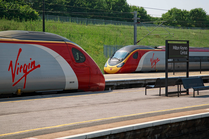 390010, VT 13.15 Manchester Piccadilly-London Euston (1A37, 7L) & 390152, VT 14.20 London Euston-Manchester Piccadilly (1H30, 14L), Milton Keynes station 
 The rear ends of two Pendolinos at Milton Keynes station. To the left is 390010 'Cumbrian Spirit' waiting to leave with the 1A37 13.15 Manchester Piccadilly to London Euston. Whilst to the right, 390152 'Virgin Knight' leaves the station working the 1H30 14.20 Euston to Manchester. 
 Keywords: 390010 1A37 390152 1H30 Milton Keynes station