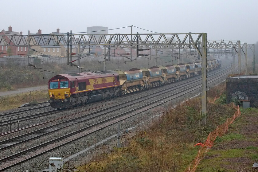 66106 & 66142, 11.50 North Wembley Junction-Bescot (6R01, 18L), site of Roade station 
 66106 emerges from the mist leading the 6R01 11.50 North Wembley to Bescot engineering train composed of a short rake of HQAE 88 tonne auto discharge bogie ballast wagons. The train is seen passing the site of Roade's former station with 66142 'Maritime Intermodal THREE' at the rear. Notice the crudely applied Network Rail vinyls on the side of the wagons half covering their original Railtrack branding. 
 Keywords: 66106 66142, 11.50 North Wembley Junction-Bescot 6R01 Maritime Intermodal THREE site of Roade station