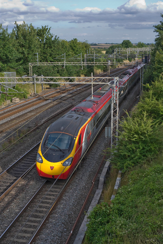 390040, VT 18.00 London Euston-Manchester Piccadilly (1H01), Victoria bridge 
 Virgin Pendolino 390040 just catches some low evening summer sunshine at Victoria bridge as it races north with the 18.00 Euston to Manchester Piccadilly. I love the flat bottomed cumulous mediocris cloud formation in this image, a typical skyscape of an English summer evening. 
 Keywords: 390040 18.00 London Euston-Manchester Piccadilly 1H01 Victoria bridge