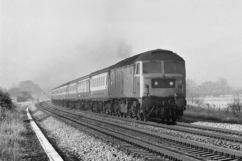 47440, 06.31 Penzance-London Paddington, Patney SU068590 
 A striking picture of 47440 as it approaches the village of Patney in Wiltshire on a very cold morning with the 06.31 Penzance to Paddington. Despite that it is past mid-morning, frost still covers the fields in the background, testament to how cold the previous night had been, and the last few weeks for that matter. 47440 was released into traffic as steam heat D1556 in February 1964 to become ETH equipped in March 1974 when it gained its TOPS number. It survived in traffic until 1994 being cut up at Old Oak Common in 1997. 
 Keywords: 47440 06.31 Penzance-London Paddington Patney SU068590