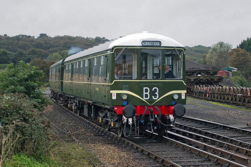 M56182 & M51188, 10.20 Holt-Sheringham, Weybourne Yard-19.10.23 
 Allegedly heading to Alderley Edge the 10.20 Holt to Sheringham DMU appears to be a little off-route! Recently restored Class 104 M56182 leaves Weybourne station leading Class 101 power car M51188. Notice the line of wheelsets to the right along with a stack of bogies, all valuable items for future reuse on the North Norfolk Railway. 
 Keywords: M56182 M51188 10.20 Holt-Sheringham Weybourne Yard Class 104 Class 101 first generation DMU