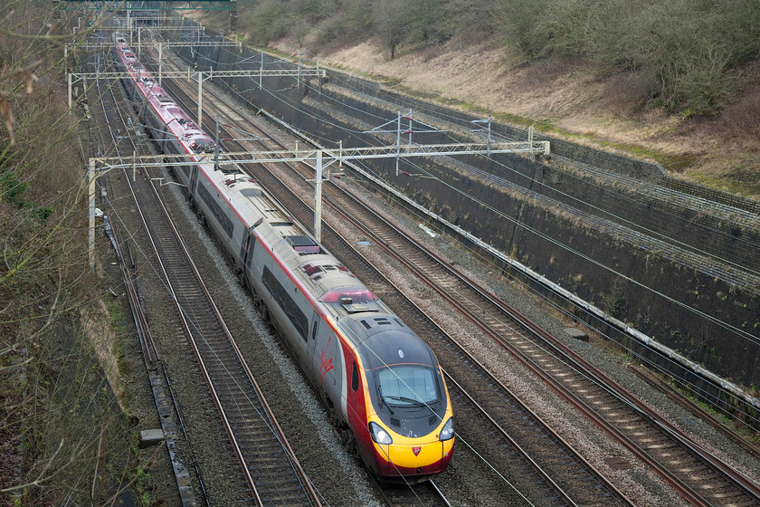 390126, VT 12.10 Birmingham New Street-London Euston (1B18, 1E), Roade Cutting 
 No doubt carrying some New Year's Eve revellers to London, 390126 'Virgin Enterprise' heads south through Roade Cutting forming the 12.10 Birmingham New Street to Euston. 
 Keywords: 390126 12.10 Birmingham New Street-London Euston 1B18 Roade Cutting