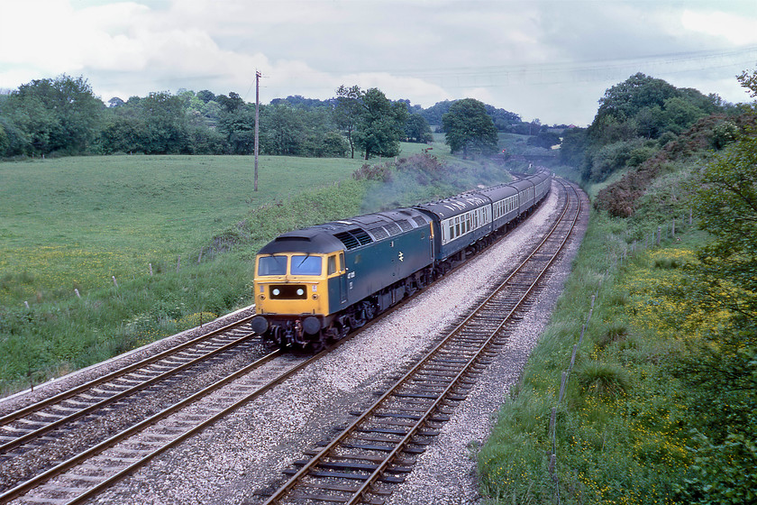 47015, 09.35 Liverpool Lime Street-Paignton (1V48), Whiteball 
 Having surmounted the summit and passed through the tunnel, 47015 passes Whiteball leading the 1V48 09.35 Liverpool to Paignton service. The Class 47 would have taken over this train at Birmingham New Street with an AC electric having hauled the service to there from Liverpool. This lovely open view from a very quiet overbridge at Whiteball that reveals the down loop is all but impossible today with rampant tree growth having all but obliterated virtually everything seen here. 
 Keywords: 47015 09.35 Liverpool Lime Street-Paignton 1V48 Whiteball