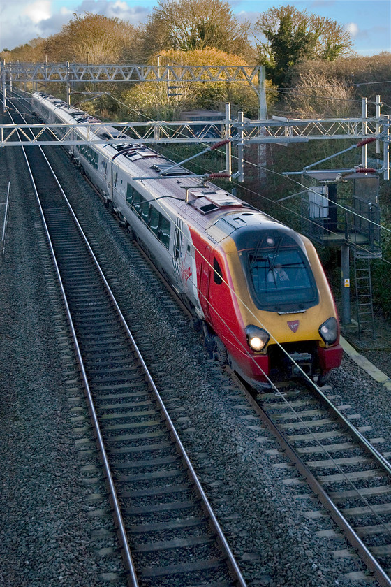 Class 221, VT 14.10 London Euston-Chester 1D68 site of Roade station 
 It is all but impossible to identify Voyagers passing on the lineside as their numbers are written so low down on the body sides and, unlike their Pendolino cousins, they have no car identifications numbers on their roofs. The 14.10 Euston to Chester Virgin Trains service passes the site of Roade's former station. 
 Keywords: Class 221 14.10 London Euston-Chester 1D68 site of Roade station Virgin Voyager