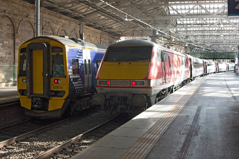 158723, SR 09.54 Edinburgh Waverley-Tweedbank (2T72) & 91107, GR 10.00 Edinburgh Waverley-London King`s Cross (1E10), Edinburgh Waverley station 
 158723 will soon work the 09.54 to Tweedbank from Edinburgh Waverley's platform one. Meanwhile, from platform two 91107 'Skyfall' will leave propelling the 10.00 to King's Cross just after the Tweedbank service. 91107 has retained its nameplates despite being renumbered following its brief life as 91007 to commemorate the release of the James Bond film in 2012. 
 Keywords: 158723 09.54 Edinburgh Waverley-Tweedbank 2T72 91107 10.00 Edinburgh Waverley-London King`s Cross 1E10 Edinburgh Waverley station