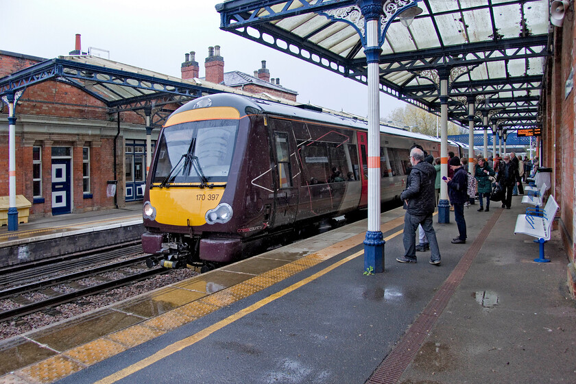 170398, XC 12.00 Cambridge-Birmingham New Street (1N53, 16L), Melton Mowbray station 
 The third train of our triangular journey around Northamptonshire, Rutland and Leicestershire arrives at Melton Mowbray in the pouring rain. The 12.00 Cambridge to Birmingham New Street was already full and standing due to the cancellation of the previous service an hour earlier and now has to accommodate perhaps another fifty travellers waiting on the platform! Luckily for Andy and me, we only had a relatively short journey of some seventeen minutes to Leicester aboard 170398 so standing in the vestibule was not too much of an ordeal! However, for others who may be infirm, old or have hidden disabilities or those with luggage who were travelling further than us this situation would have been very uncomfortable. 
 Keywords: 170398 12.00 Cambridge-Birmingham New Street 1N53 Melton Mowbray station CrossCountry XC Turbo