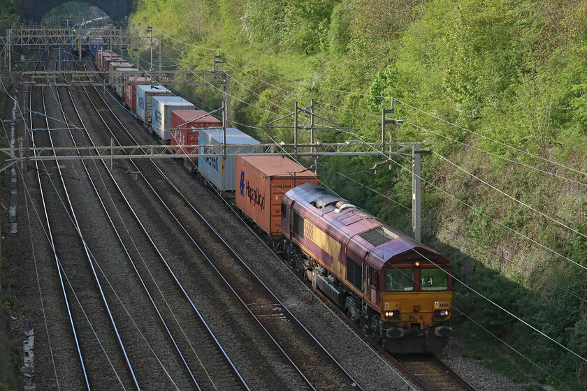 66188, 13.20 Trafford Park-London Gateway (4L56, 2L), Hyde Road bridge 
 The final freight of my forty-minute session on Roade's Hyde Road bridge passes southwards with the illumination of the bottom of the cutting now very tricky. To avoid the greenery and background being overexposed and burnt out I locked the camera on to this area securing its exposure. This leaves the foreground and the train about two stops underexposed and rather dark in its RAW form. However, the remarkable abilities of Photoshop allow me to then isolate the dark area and work on it to bring back the detail. This increases noise levels a little with Neat Image able to then deal with this admirably. All this reveals 66188 ponderously making its way through the cutting leading the 12.30 Trafford Park to London Gateway 4L56 service; time to go home for a cup of tea now! 
 Keywords: 66188 13.20 Trafford Park-London Gateway 4L56 Hyde Road bridge EWS DB Cargo