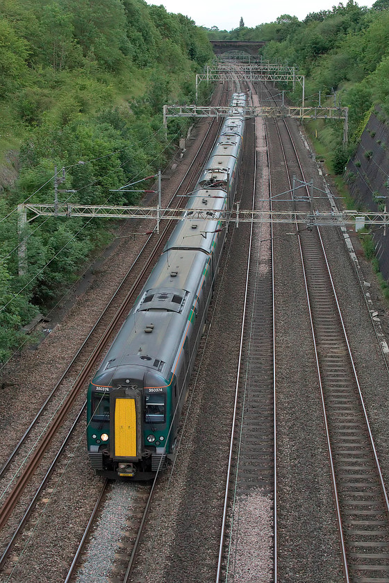 350374 & 350103, LN 18.24 London Euston-Rugeley Trent Valley (9K72, 8L), Roade Cutting 
 350374 and 350103 pass through Roade Cutting forming the 9K72 18.24 Euston to Rugeley Trent Valley. The green front end livery of the 350 does its best to blend in with the summer foliage of the cutting! 
 Keywords: 350374 350103 18.24 London Euston-Rugeley Trent Valley 9K72 Roade Cutting