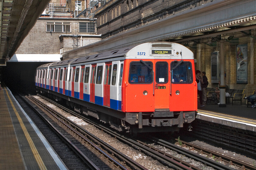 5572, ACW Circle Line working, High Street Kensington station 
 The withdrawal of the C69 stock is well underway with a set coming out of service every week or two before then going for scrap. They are being replaced by the new but troublesome S7 stock but this is not going entirely to plan. 5572 arrives at High Street Kensington with an anticlockwise Circle Line working catching some welcome late summer sunshine. 
 Keywords: 5572 Circle Line working High Street Kensington TfL station C69 stock