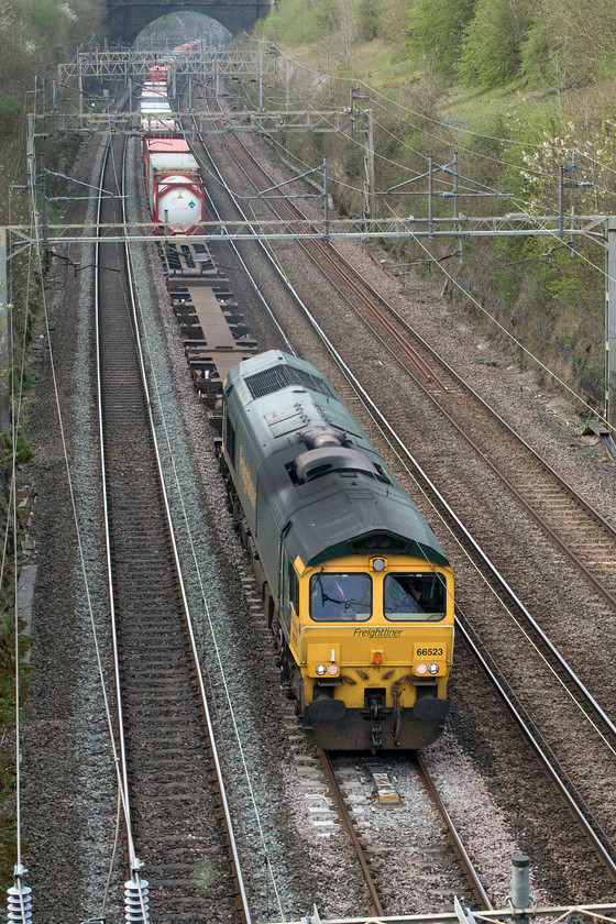 66523, 14.03 Ditton-Felixstowe North (4L92, 2E), Roade Hyde Road bridge 
 'On the up fast' (so as to coin a phrase!) 66523 emerges from Roade cutting taken from the village's Hyde Road bridge leading the 14.03 4L92 Ditton to Felixstowe multimodal train. After a glorious early spring day, the sun had gone behind a veil of high cloud thus taking the edge off the lighting. 
 Keywords: 66523 14.03 Ditton-Felixstowe North 4L92 Roade Hyde Road bridge Multimodal Freightliner