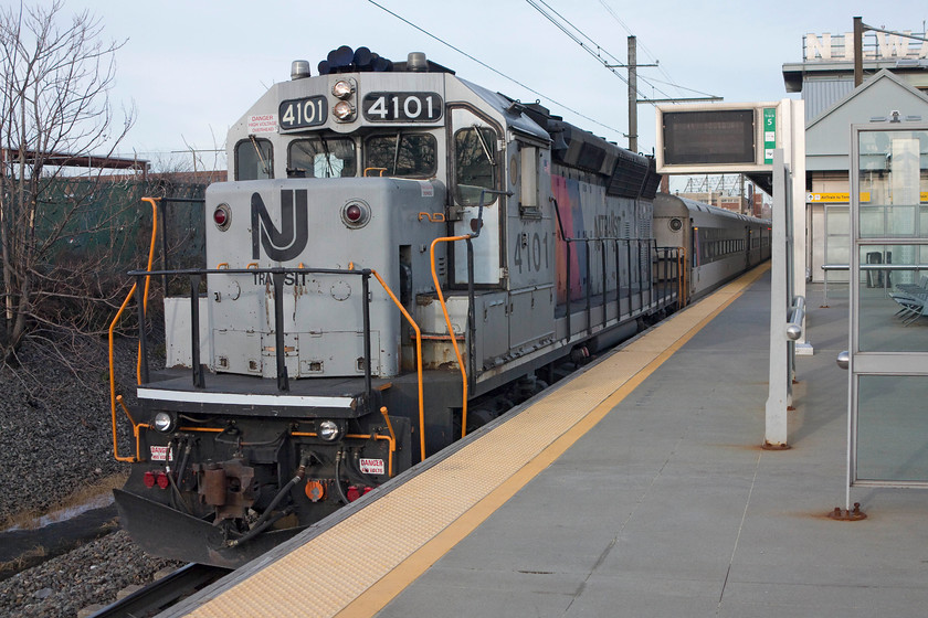 4101, 14.12 New York-Hoboken Bay Head (2303), Newark International Airport station 
 I don't know what it is about American machinery, but it wins no awards in the styling stakes! Like their cars of the 1960s, these GM EMD GP40 locomotives are ugly and cluttered, but could only be an American design. Here, one of the few remaining examples of these 3 000hp locomotives operating for NJ Transit Rail Operations, 4101, is seen pausing at Newark International Airport station with the 14.12 New York Penn to Hoboken Bay Head 2302 service. The size and design was as grand as the noise it made, the thundering of the engines and the screaming turbo chargers were something to behold! 
 Keywords: 4101 14.12 New York-Hoboken Bay Head 2303 Newark International Airport station