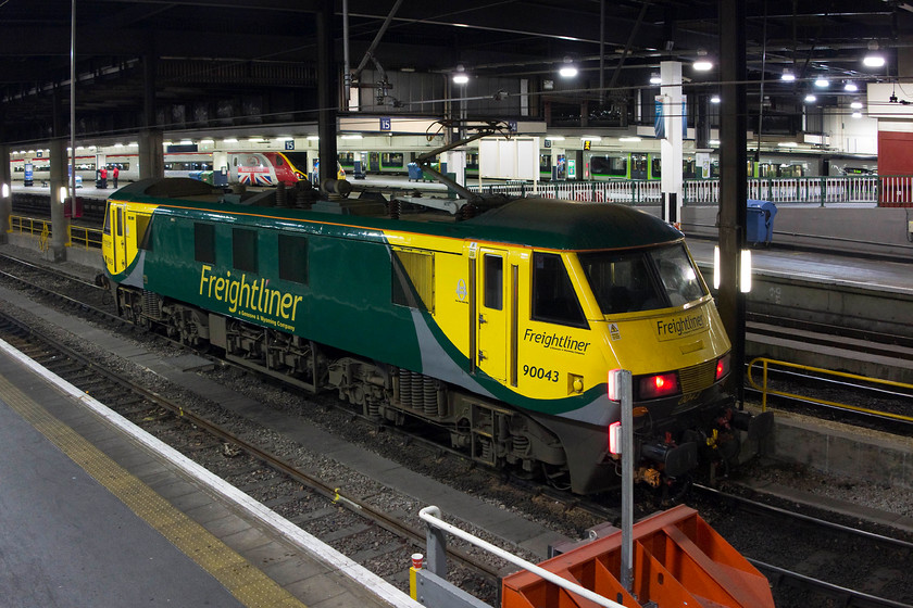 90043, stabled, London Euston station 
 Freightliner 90043 sits stabled at London Euston station. Often on arrival or departure at Euston there are random locomotives sitting at the stops for no apparent reason. In the background, the Pendolino can easily be identified as being 390151 due the huge Union flag adorning the power car. 
 Keywords: 90043 London Euston station