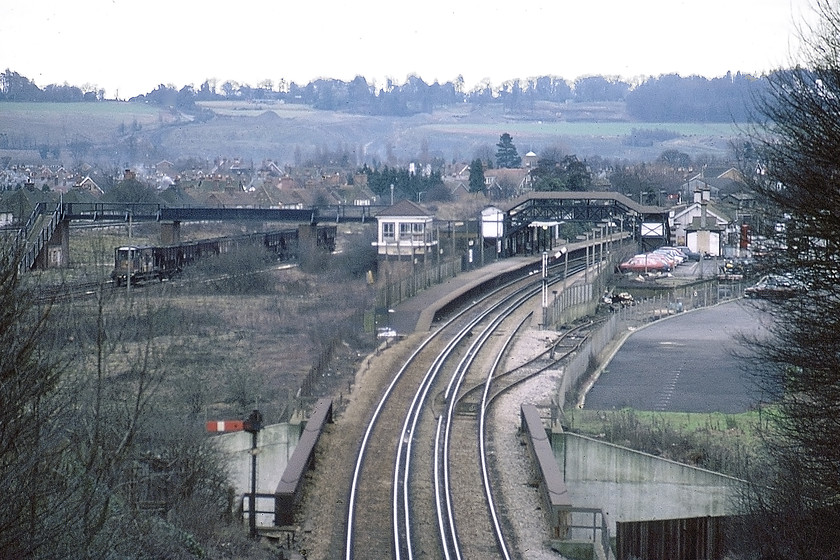 Merstham station & signal box (SE&C, 1905)-29.12.80 
 Taken from Rockshaw Road using my telephoto lens Merstham station is seen located on the former South Eastern & Chatham Railway route between Brighton and Charing Cross. On the down platform, the signal box can be seen, a SE & C structure dating from 1905. To the left beyond the stored wagons and brake van are some sidings and then the lines of the London and Brighton Railway route. Both routes have just emerged from parallel tunnels that have passed under the North Downs. 
 Keywords: Merstham station signal box