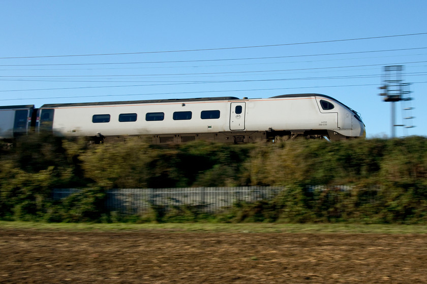 390039, VT 07.04 Wolverhampton-London Euston (1B05, RT), Milton Crossing 
 The rear power car of 390039 'Lady Godiva' heads south past Milton Crossing between Blisworth and Roade working the 07.04 Wolverhampton to Euston. After being the norm for some time now, these plain white Pendolinos are now being rebranded into Avanti West Coast's house colours. I have said it before and will repeat myself that it's so noticeable in this livery, for want of a better phrase, how small the windows are on the Pendolino fleet - just compare with the flank of an early Mk.I or Mk.II coach. 
 Keywords: 390039 07.04 Wolverhampton-London Euston 1B05 Milton Crossing Avanti West Coast Pendolino Lady Godiva