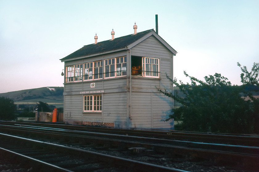 Heywood Road Junction signal box (GW, 1933) 
 Overlooked by the one hundred and eight-foot-long Westbury White Horse (or Bratton Horse depending upon where you come from!) the 1933 GW Type 28B Heywood Road Junction signal box just catches the final vestiges of the evening light. The signalman was very accomodating to Graham and I allowing us to take this photograph and the one of the light engine approaching from the west as in the next image. The box opened in 01.01.33 together with the Westbury avoiding line and its matching twin Fairwood Junction at the western end of the avoider some 2.3 miles away. 
 Keywords: Heywood Road Junction signal box