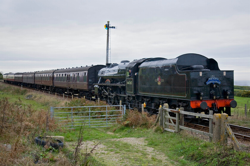 44767, 14.14 Holt-Sheringham & dining train, North End Hollow TG144432 
 44767 'George Stephenson' leads the final leg of The North Norfolkman dining train as it approaches Sheringham with the 14.14 ex Holt. The train is seen passing Sheringham's fixed distant signal with the golf club in the background. This dining train is a good revenue generator for the railway and runs regularly on Sunday's throughout the season. The NNR simply add three dining cars to their scheduled service train and bring in a crew to treat customers to a slap-up four-course meal at a price of course! 
 Keywords: 44767 14.14 Holt-Sheringham & dining train North End Hollow TG144432 Black 5 George Stephenson