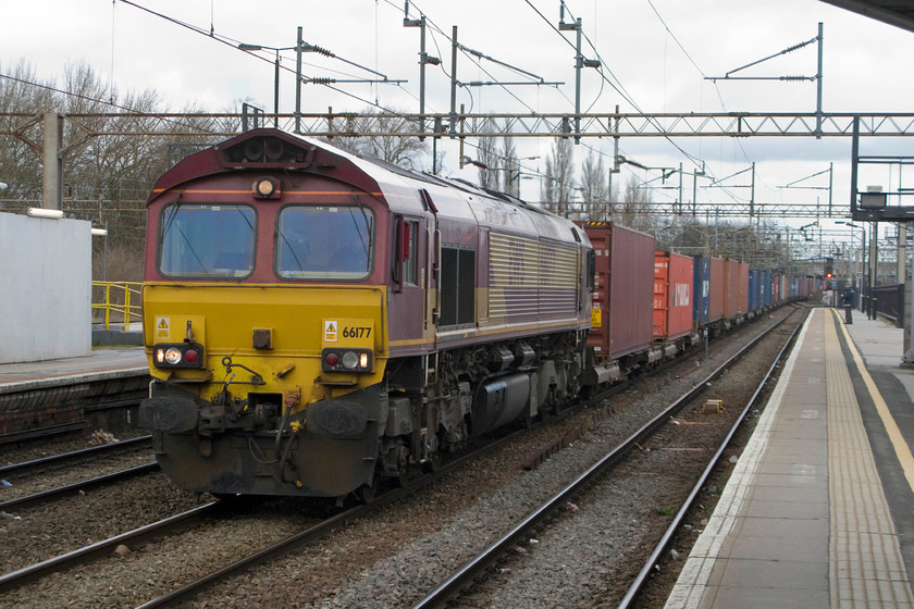 66177, 09.15 Trafford Park-Southampton Western Docks, Northampton station 
 66177 brings the 09.15 Trafford Park to Southampton Western Docks Freightliner slowly through Northampton's centre road. This particular service is rarely seen on the WCML usually going via the GW route through Banbury. However, the latter route is currently closed dues to the huge landslide in Harbury cutting severing the route. It is difficult to see in this image, this particular Class 66 retains white painted cab roofs. This was applied to a small number of the class as an experiment to try to improve conditions inside the cab for drivers during hot weather with these locomotives having no air conditioning fitted. As can be seen in this image, this was a typically dull February day. 
 Keywords: 66177 09.15 Trafford Park-Southampton Western Docks, Northampton station