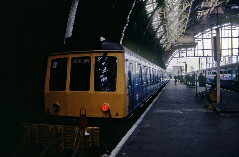 Class 127 DMU, 16.42 London St. Pancras-Bedford, London St. Pancras station 
 This was a transparency rescued from the rejects box due to its chronic underexposure but one that Photoshop has made a reasonable job of recovering. A pair of four-car Class 127 DMUs stands at St. Pancras' platform one that will soon work the 16.42 service to Bedford. These venerable Derby built units were the mainstay of inner and out suburban services on the Midland route running as far north as Bedford from London hence them acquiring their Bedpan nickname. 
 Keywords: Class 127 DMU 16.42 London St. Pancras-Bedford London St. Pancras station