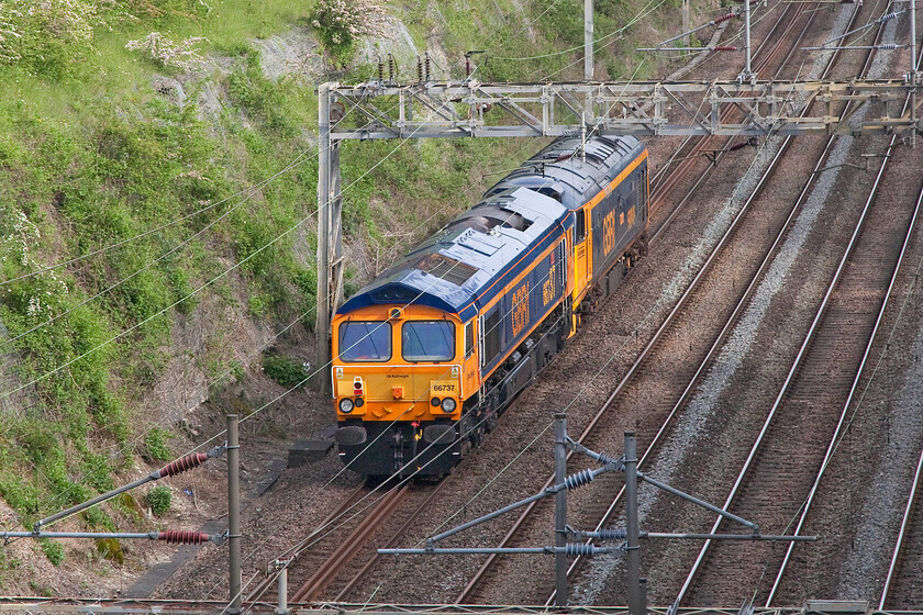 66737 & 50049, 15.06 Kidderminster SVR-Stewart's Lane (0Z60, 2E), Roade cutting 
 From this reverse view of the 0Z60 15.06 Kidderminster SVR to Stewert's Lane light engine move there appears to be a strange optical illusion making the bulk of 50049 'Defiance' appear larger than that of the far more modern 66737 'Lesia'. The GBRf compatriots are seen passing south through Roade cutting on a sunny afternoon. Apologies for not getting the framing quite right by pressing the shutter a millisecond too late; going away shots are always more tricky to take! In addition, I do not tend to depend on the camera's rapid burst mode rather than using my eye-brain-finger coordination skills! 
 Keywords: 66737 50049 15.06 Kidderminster SVR-Stewart's Lane 0Z60 Roade cutting Lesia Defiance GBRf