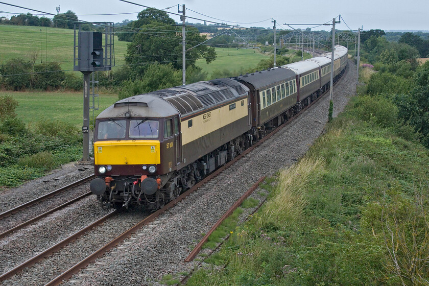 57601, 09.02 London Euston-Milton Keynes Central (via Rugby) (1Z28, 4L), Milton crossing 
 57601 'Windsor Castle' leads the 09.02 London Euston to Milton Keynes past Milton crossing just south of Blisworth in Northamptonshire. Observers will notice that the train is running south which would appear to be incorrect but, in fact, the train had made an extra reverse run to Rugby via the Weedon 'old' route before then depositing its passengers at Milton Keynes for onward bus transportation to Silverstone. This extra run up the line gave the premium fare-paying passengers time to enjoy their champagne breakfasts that would start off their day. 
 Keywords: 57601 09.02 London Euston-Milton Keynes Central Rugby 1Z28 Milton crossing West Coast Railway Pullman Windsor Castle