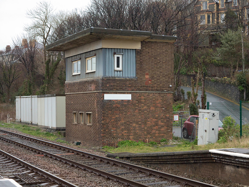 Penmaemawr Signal Box (BR, 1952) 
 Penmaemawr signal box is seen at the eastern end of the station. The top has been drastically modified in more recent years with its original steel framed windows completely removed and replaced by the ghastly cladding and UPVC windows. The box was built by British Railways in 1952 to the standard LMS 1948 design. It was built in this revised location due to a serious and fatal collision on 5th August 1950 involving the up night boat train (the Irish Mail) hitting a stationary locomotive. As part of the enquiry, it was stated that the poor siting from the old signal box was a major contributory factor in the collision. When I last visited the box back in 1981 it was in its as-built condition, see.... https://www.ontheupfast.com/p/21936chg/30035069789/x32-penmaenmawr-signal-box-br-1952 
 Keywords: Penmaemawr Signal Box BR 1952