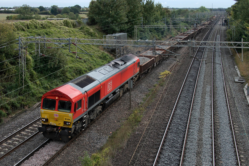 66034, 10.41 Willesden West London Junction-Bescot Down Side (6R01), Victoria Bridge 
 66034 received its DB red livery almost exactly a year ago. Given that, it still looks very smart and brings a flash of light to an autumnal afternoon. It is leading the 10.41 Willesden to Bescot engineers' train that was mainly conveying used ballast back to the Midlands for recycling. 
 Keywords: 66034 10.41 Willesden West London Junction-Bescot Down Side 6R01 Victoria Bridge