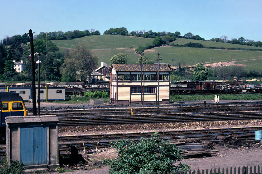 Exeter Riverside signal box (GW 1943, ex. Hatherley Junction, 1906) 
 A signal box that was always very difficult to get a photograph of was Exeter Riverside being in the middle of the yard of the same name. The yard was hastily constructed during World War Two to assist with the war effort with the box to control its movements built in 1943. It was second hand being moved from Hatherley Junction in Cheltenham with an austere wartime structure built there that, at the time of writing, is still standing but in a very sorry state. By the time this photograph was taken Riverside box was not routinely manned as it only controlled access in and out of the yard and within it. The yard is being used for the storage of a huge array of wagons and brake vans many of which were probably destined for the scrap man. Notice the unidentified Class 47 stabled to the left. 
 Keywords: Exeter Riverside Signal Box