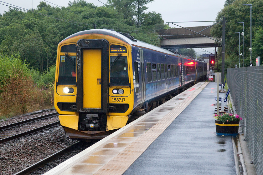 158717 & 158712, SR 09.31 Tweebank-Edinburgh Waverley (2T67, RT), Newcraighall station 
 In appalling light and wet conditions, a four-car set composed of 158717 and 158712 arrives at Newcraighall station. The train was forming the 09.31 Tweedbank to Edinburgh service that had just traversed the highly popular Borders route and judging by the passengers struggling for shelter on the platform and the numbers already on the train this service was well supported. Despite appearances, Newcraighall station has only a single platform with the Border Line trains using it in a bi-directional manner with the line curving off to the right just beyond the furthest bridge. The line on the left curves sharply into Millerhill yard and to then re-join the ECML at Monktonhall Junction after a short and somewhat convoluted section of track. 
 Keywords: 158717 158712 09.31 Tweebank-Edinburgh Waverley 2T67 Newcraighall station