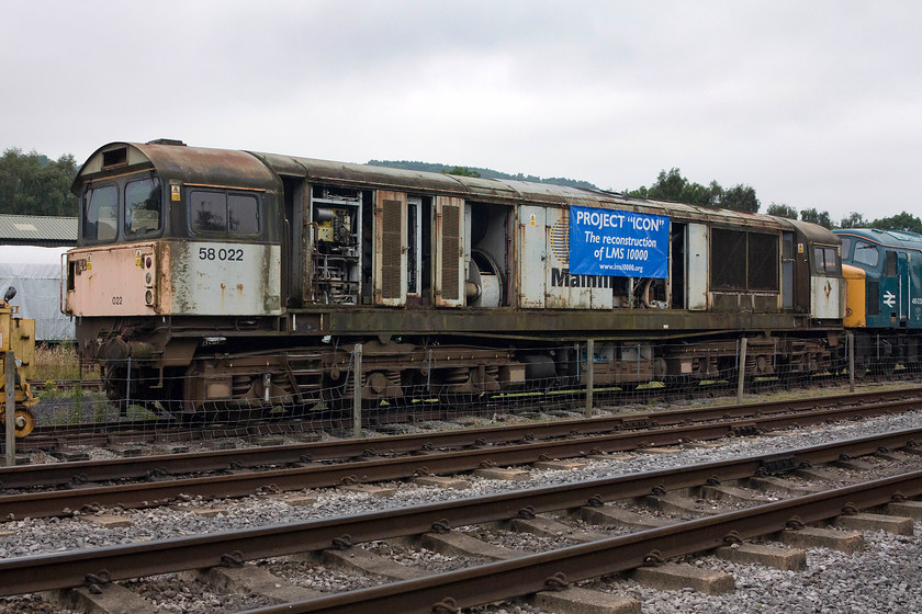 58022 & 46035, stabled, Rowsley South 
 The sad hulk of 58022 stands in Peak Rail's Rowsley yard. However, if the ambitions of Project 'Icon' are to be realised, then the loco will run agin, at least the frame will as a replica of the former LMS 10000. 58022 was a 1985 Doncaster built loco. that had only recently arrived from Crewe having been purchased by the organisation behind the project. Behind the class 58 is 46035 stored in BR blue. 
 Keywords: 58022 46035 Rowsley South