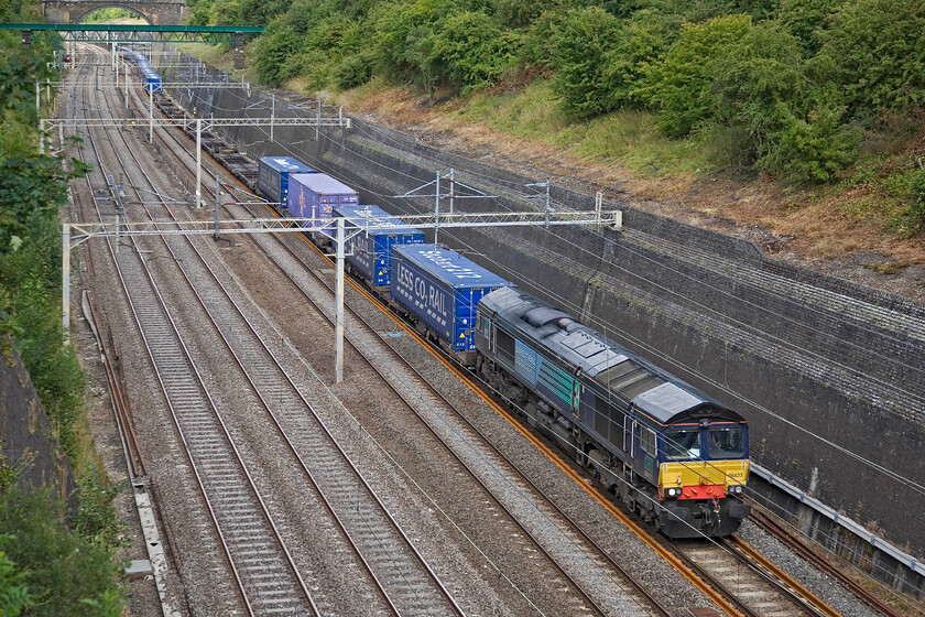 66423, 12.03 Daventry-Tilbury 4L48 Roade cutting 
 The daily 4L48 up Tesco Express slogs through Roade cutting against the gradient hauled by 66423. This train is, today, a little lighter than normal with a big gap towards the front with no boxes. 
 Keywords: 66423, 12.03 Daventry-Tilbury 4L48 Roade cutting DRS Tesco Express