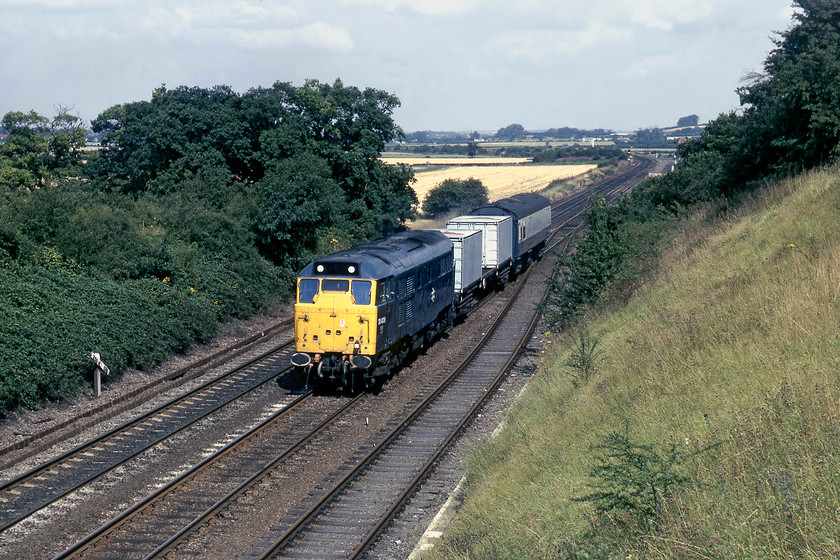 31409, up bullion working, Eaton Wood SK723774 
 After the beautiful start to the day, the inevitable cloud has built up but at least the sun is still out as 31409 passes Eaton Wood with a strange up working. According to one of my readers, Ed Harman (https://www.flickr.com/people/robertcwp/) this appears to be one of the bullion trains operated by BR. In the consist are two bogie bullion flats (probably E99500 and E99501) and a converted Mk. I BSK bullion van (probably E99204). Close examination of the latter shows most of its windows plated over. According to contemporary information, these trains, allegedly, ran with armed security guards on board both the van and the cab and had special signalling arrangements. It is likely that this particular working originated from either Leeds or Newcastle and would terminate at King's Cross' Mill Dock adjacent to the suburban platforms. It would have been carrying used banknotes being withdrawn from circulation. 
 Keywords: 31409 up short freight Eaton Wood SK723774