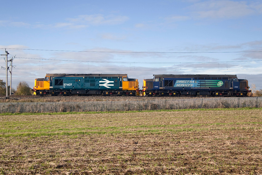 37407 & 37605, 06.50 Crewe Gresty Bridge-Willesden Brent Sidings, Milton Malsor SP740557 
 I had been watching this mysterious working on my 'phone using Open Train Times not knowing what it was as there had been no internet postings. As it approached, out of view, I heard the familiar sound of an English Electric 12CSVT engine opening up. Within seconds, I realised that there was two locomotives so had to quickly adjust the focal length of the lens to accommodate them! I had opted for a fast shutter speed (1/2500 sec) rather than a pan shot. The image shows 37407 and 37605 running as the 06.50 Gresty Bridge to Wembley that was unexplainably terminated at Willesden Brent Sidings passing Milton Malsor just south of Northampton. 
 Keywords: 37407 37605 06.50 Crewe Gresty Bridge-Willesden Brent Sidings Milton Malsor SP740557