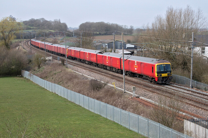 325005, 11.20 Crewe TMD-Willesden PRDC (5A91, 7E), Banbury Lane bridge 
 325005 leads two other members of the class of fifteen units past the former Banbury Lane level crossing in rural Northamptonshire. They are working the daily 11.20 Crewe TMD to Willesden Park Royal Mail depot empty stock move. This train is not uncommon on the 'fast' Weedon route avoiding Northampton with the mood of the signaller seeming to be the deciding factor on its routing! 
 Keywords: 325005 11.20 Crewe TMD-Willesden PRDC 5A91 Banbury Lane bridge Royal Mail