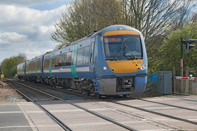 170202, LE 13.20 Ipswich-Cambridge (2W16, RT), Elmswell station 
 170202 crosses the level crossing in the village of Elmswell as it slows for the station. This is the 13.20 Ipswich to Cambridge service that is about one third into its journey at Elmswell. 
 Keywords: 170202 2W16 Elmswell station