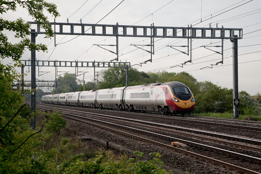 390138, VT 07.20 London Euston-Manchester (1H09, 41L), Ashton Road Bridge 
 Virgin Trains 390138 'City of London' forms the 07.20 London Euston to Manchester Piccadilly as it passes Roade in Northamptonshire. Something obviously went wrong further 'up north' as it arrived 41 minutes late into its destination. 
 Keywords: 390138 1H09 Ashton Road Bridge