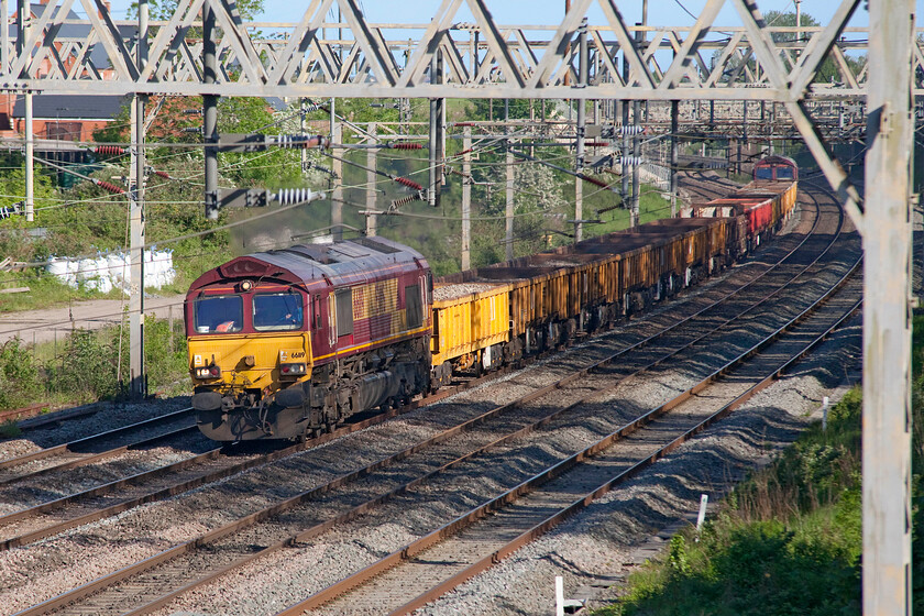 66119 & 66014 19.30 Ledburn Junction-Bescot (6R05, 109E), site of Roade station 
 With a fair amount of heat haze emanating from the exhaust 66119 leads the 6R05 very early running 19.30 Ledburn Junction to Bescot infrastructure working. The train is seen passing Roade with 66014 dead in tow on the rear. I expected not to able to see this train as we had a family barbeque arranged when it was due to pass. However, after seeing the preceding 6R01 as I was walking home I happened to check my 'phone that revealed that this one had left Ledburn Junction and that it was already underway and passing Bletchley so I returned to whence I came! 
 Keywords: 66119 66014 19.30 Ledburn Junction-Bescot 6R05 site of Roade station EWS DB