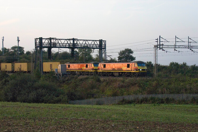 90012 & 90007, 02.57 Felixstowe North-Garston (4M45, 38E), between Roade & Ashton 
 Catching the very first vestiges of early morning sun the 4M45 02.57 Felixstowe to Garston Freightliner passes between Roade and Ashton. 90012 and 90007 lead the train but for how much longer given that Freightliner has announced their intention to reduce the electric haulage of their services due to the increasing cost when compared to diesel that is until that situation is reversed again! 
 Keywords: 90012 90007 02.57 Felixstowe North-Garston 4M45 between Roade & Ashton Freightliner