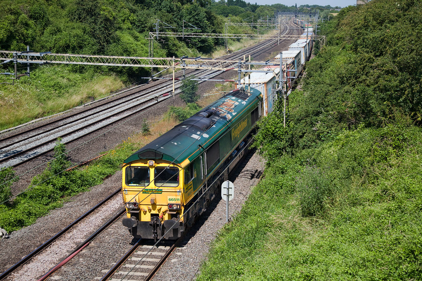 66511, 10.08 Lawley Street FLT-London Gateway (4L93), Victoria Bridge 
 A shot that illustrates clearly the issues when photographing in high summer! With the roof and front lit, the sides are in deep shadow making it a difficult shot to get exposed correctly. 66511 leads the 10.08 Lawley Street to London gateway Freightliner past Victoria Bridge just south of Roade. Notice the roof of the 66 with huge areas of paint peeling away and consequential corrosion beginning to set in. Externally, Freightliner locomotives are not not kept in great condition unlike other companies like DRS. 
 Keywords: 66511 10.08 Lawley Street FLT-London Gateway 4L93 Victoria Bridge