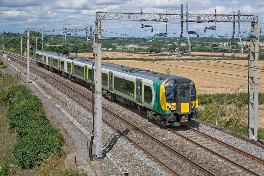 350264, LM 09.54 Crewe-London Euston (1U26), Blisworth 
 In strong summer sunshine 350264 works the 09.54 Crewe to Euston service past Blisworth on the Weedon line. In the week, this train would pass this way as a matter of course but not at weekends when they serve Northampton. However, today with the latter route closed for engineering works a number of passengers will have alighted at Rugby to be bussed to Long Buckby and Northampton. 
 Keywords: 350264 09.54 Crewe-London Euston 1U26 Blisworth London Midland Desiro