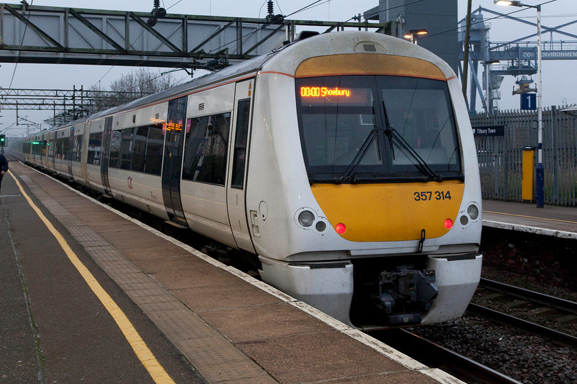 357314, CC 18.25 London Fenchurch Street-Shoeburyness (1D64, 1L), Tilbury Town station 
 Taken on the journey down to Kent at Tilbury Town station just before we crossed the Thames Estuary over the bridge. In utterly dismal light the 18.25 from Fenchurch Street to Shoeburyness worked by 357314. Unlike most of C2C's stations, this was an 'open' one. Andy and I have always found access on to C2C stations a tricky proposition with a general unwillingness almost staff to permit access. 
 Keywords: 357314 1D64 Tilbury Town station