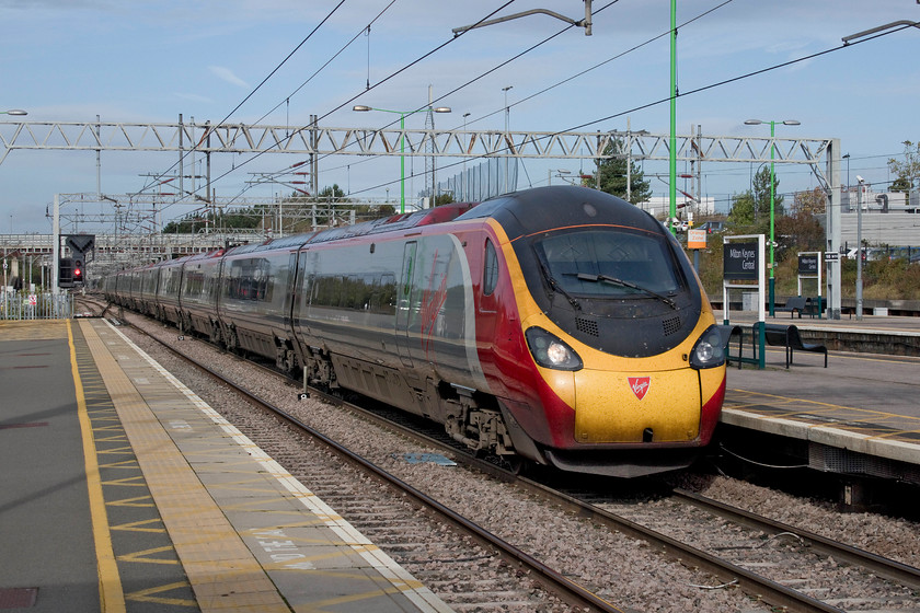 390157, VT 09.47 Liverpool Lime Street-London Euston (1A20, 1L), Milton Keynes Central station 
 390157 'Chad Varah' races through Milton Keynes station working the 09.47 Liverpool Lime Street to Euston. Milton Keynes station is located forty-nine miles north of Euston and was opened in May 1982 to serve the large and ever-growing new town. In recent years it has been expanded and re-modelled. 
 Keywords: 390157 09.47 Liverpool Lime Street-London Euston 1A20 Milton Keynes Central station