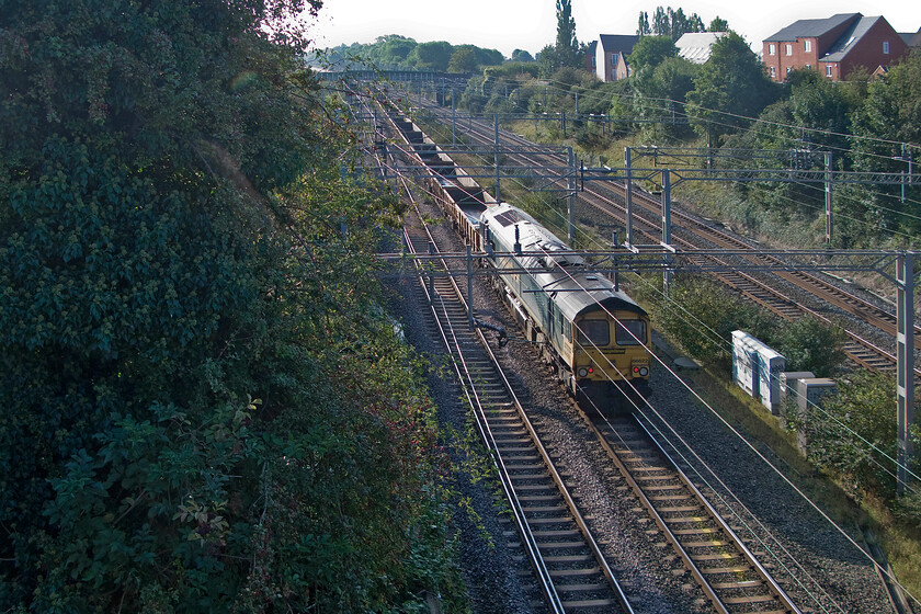 66522, switched off, ballast train, A508 bridge 
 This is a viewpoint that, to date, that I only have one photograph of due to its awkward position. It is taken from Roade's A508 road bridge on the side where there is no pavement. Usually, unless it was a Sunday morning, the bridge would be rammed with cars, HGVs and busses all vying for space that would make mincemeat of a railway photographer! 66522 is seen at the head of a shortish rake of open ballast wagons that were involved in work in Roade cutting a short distance north of this location. 
 Keywords: 66522 ballast train A508 bridge