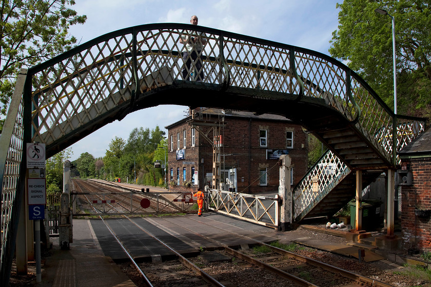 Closing crossing gates, Brundall Level Crossing 
 Andy, my companion, stands on Brundall's footbridge taking in the delightful scene as the crossing keeper closes the level crossing for the passage of another train. Stations with so much Victorian infrastructure are now in extremely limited supply. Because of this, Brundall has always been one of my favourites and once it all is swept away in the name of progress, I am not sure that I will want to re-visit it again? 
 Keywords: Closing crossing gates, Brundall Level Crossing