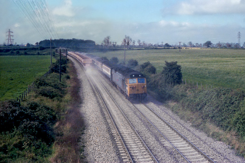 50033, unidentified up working & 46001, down empty stone working, Berkeley ST805497 
 The dust is flying around at Berkeley near Frome as an empty stone train heads west to one of the Mendip quarries lead by 46001. The dust is almost obliterating 50033 Glorious leading an unidentified up working to Paddington. Glorious was one of the chosen ones as it was saved from the scrap man and can be enjoyed today on the Severn Valley Railway. It is undergoing a rolling restoration looking quite something in its green primer when it took part in the 50th anniversary of the 50s celebrations at the SVR in October 2018. 
 Keywords: 50033 up working 46001 stone working Berkeley ST805497