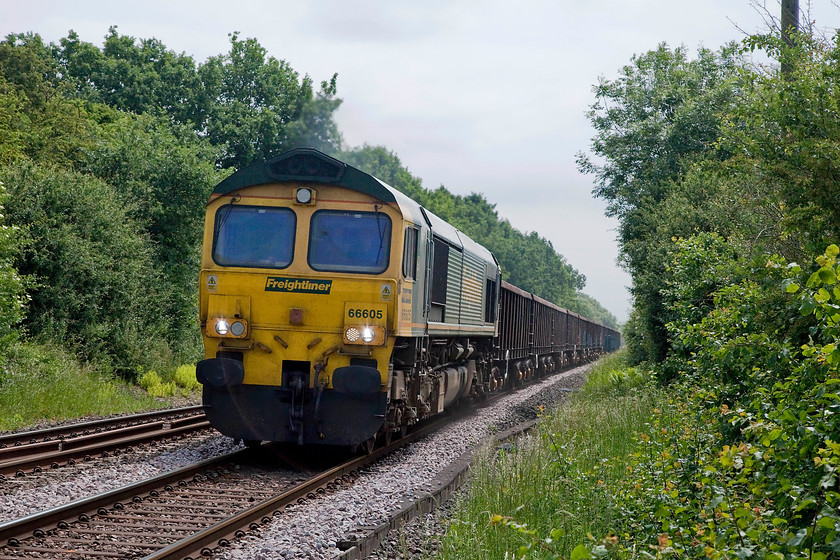 66605, 11.45 Chesterton Junction-York Yard South, Egleton SK869070 
 This had been a spot that I had passed a number of times but never stopped at. I looked at www.suncalc and realised that the sun would be right for the intended working. Unfortunately, for workings in the other direction, such as this one, it was not right! Never mind, a veil a high cloud had improved matters! 66605 passes Egleton near Oakham with the 11.45 Chesterton Junction to York Yard stone train. This picture is taken from a public footpath crossing. 
 Keywords: 66605 11.45 Chesterton Junction-York Yard South Egleton SK869070