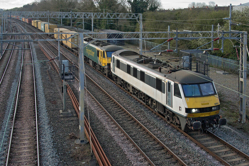 90003 & 90045, 02.50 Felixstowe North-Garston (4M45, 54E) site of Raode station 
 As the fast lines around Weedon (as opposed through Northampton) were a little quieter due to the seventy-five per cent COVID timetable and that the train was 'super power' hauled signallers send the 4M45 02.50 Felixstowe to Garston Freightliner on that route. Leading this train is former Greater Anglia 90003 that was named 'Raedwald of East Anglia' and was seen a number of times in its previous life, for example, see..... https://www.ontheupfast.com/p/21936chg/29996910004/x90003-06-48-norwich-london-liverpool Freightliner stalwart 90045 is tucked in second but is unfortunately partially obscured by the electrification mast due to the cramped positioning of the photograph. 
 Keywords: 90003 90045 02.50 Felixstowe North-Garston 4M45 site of Roade station Freightliner 'Raedwald of East Anglia'